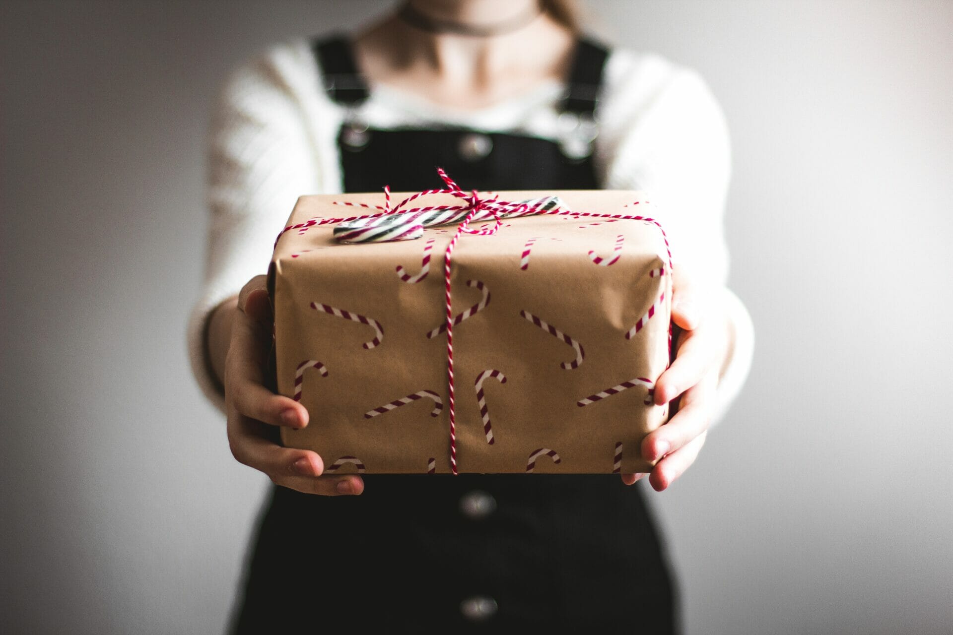 kira-auf-der-heide-IPx7J1n_xUc-unsplash Person handing a present showing "selling your business"